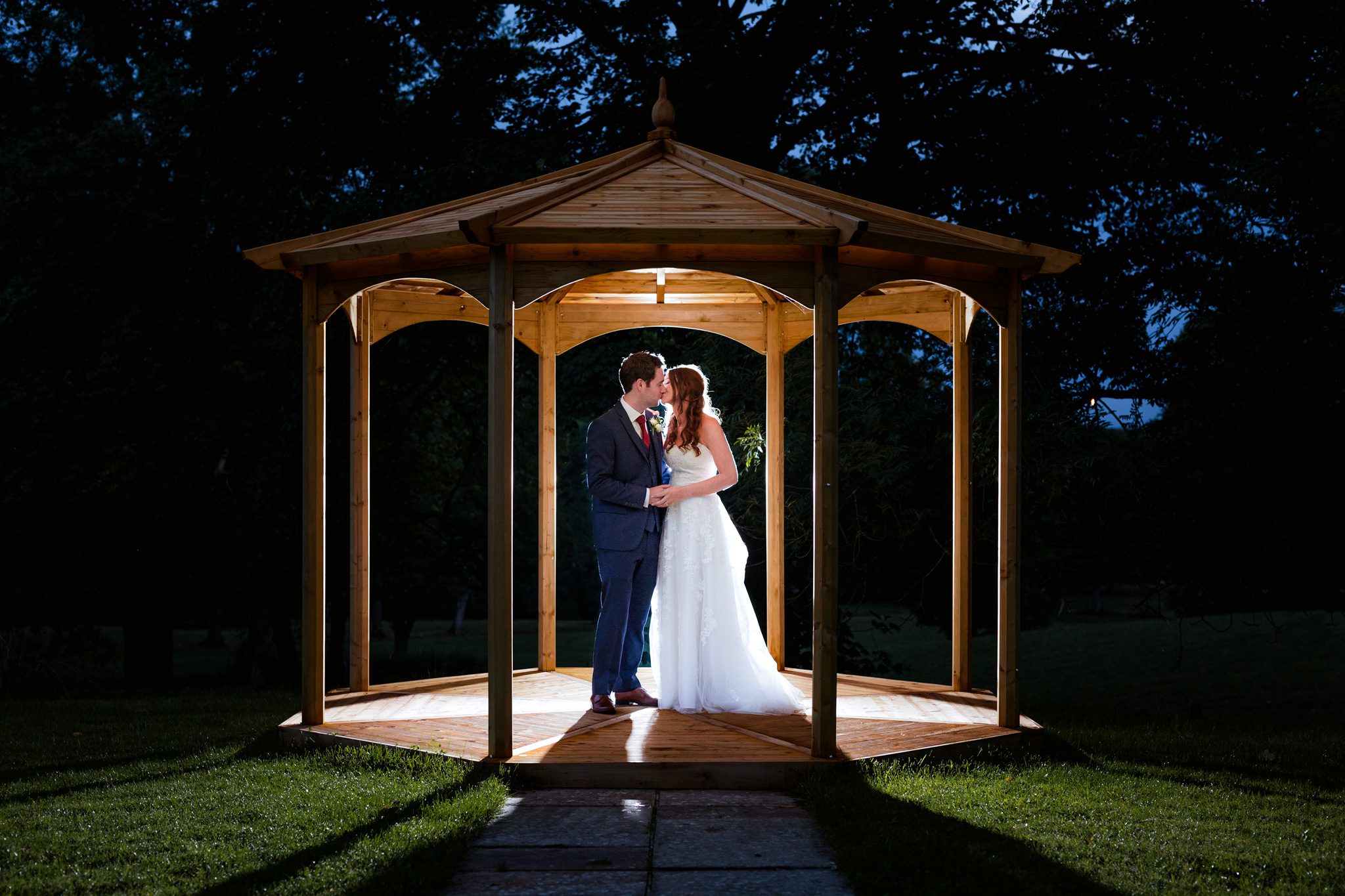 Night Portraits at Losehill House. Sarah and Ryan are lit up by flash behind them under the band stand.